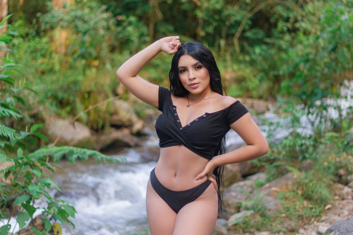 a woman in a black bikini posing for a picture