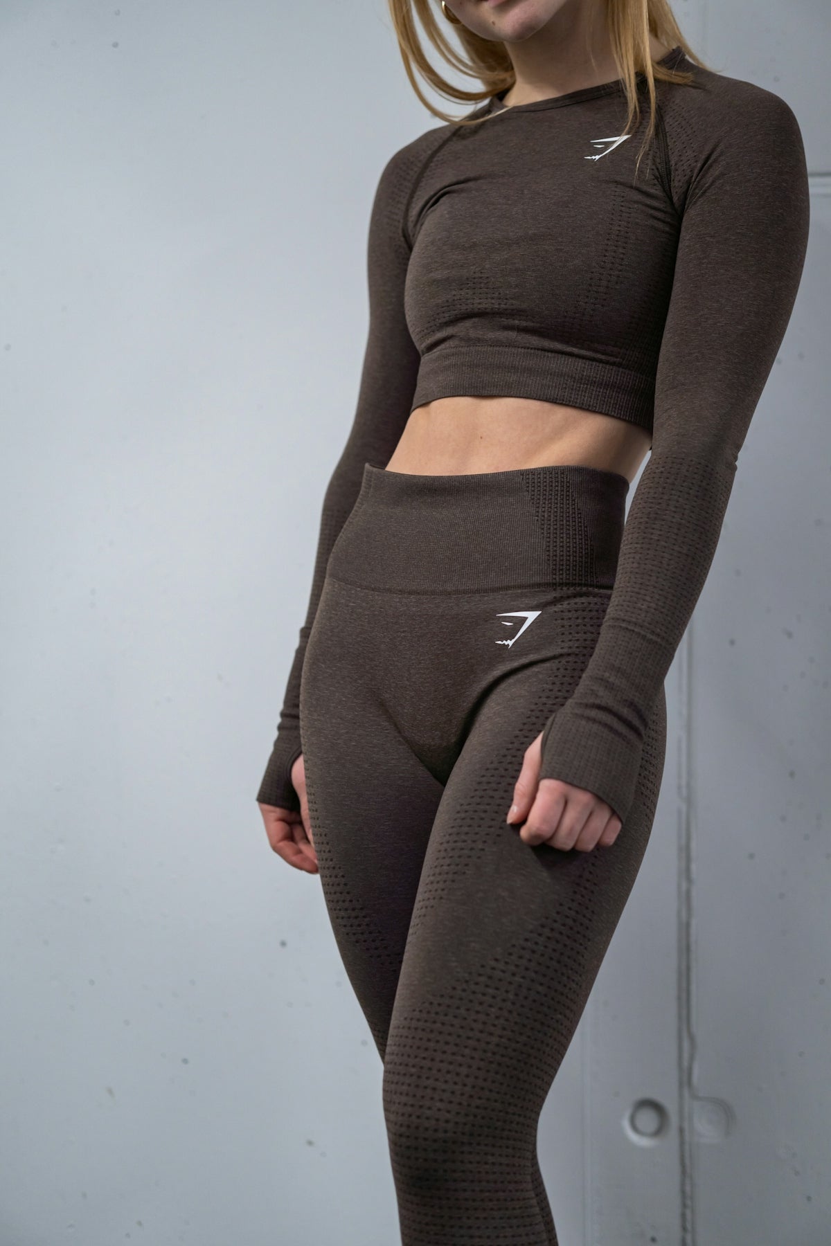 a woman in a brown top and leggings