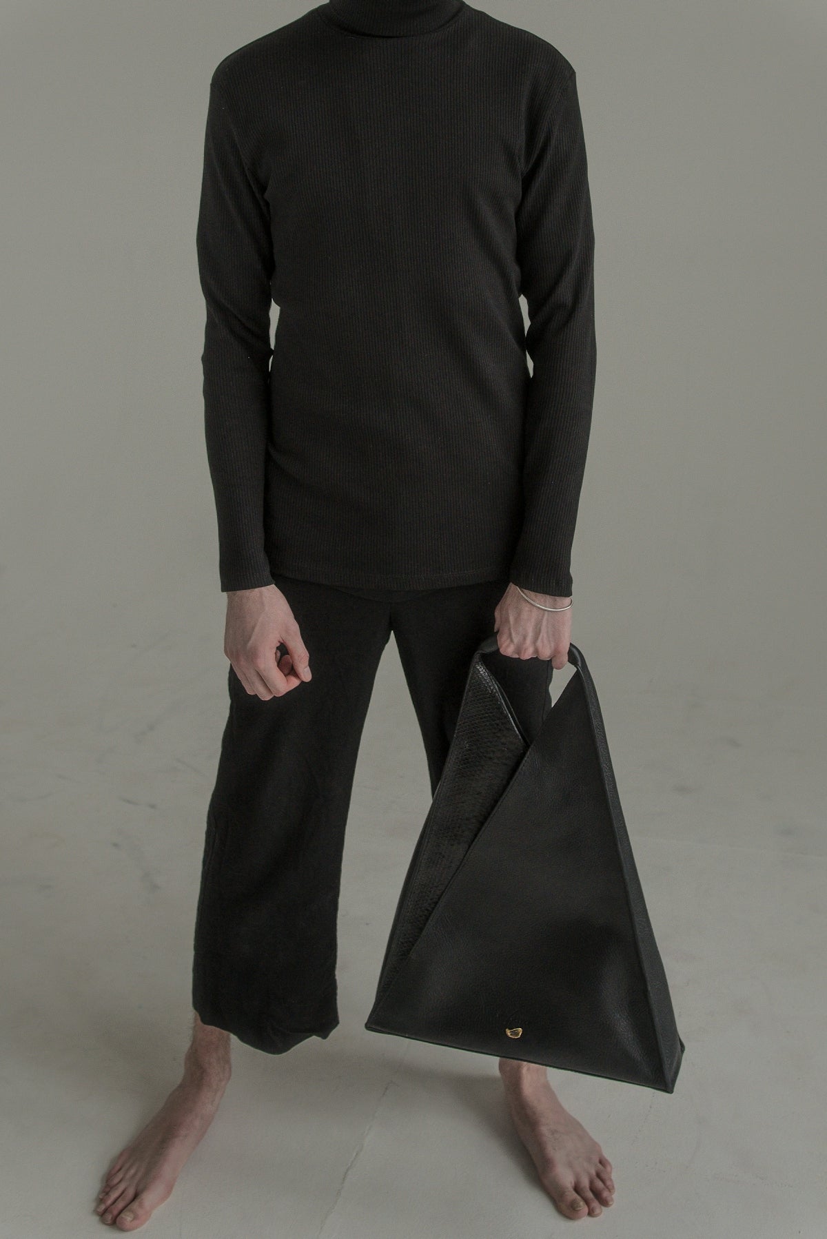 a man in black is holding a black bag