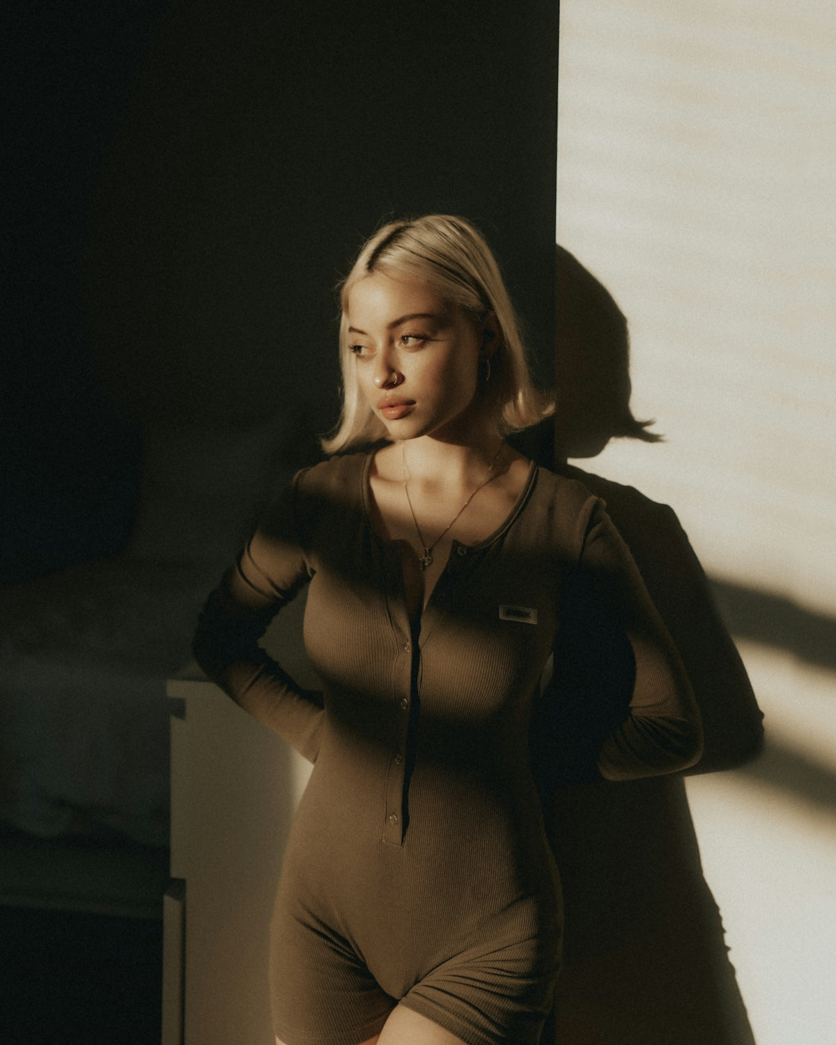A woman in a bodysuit posing for a picture