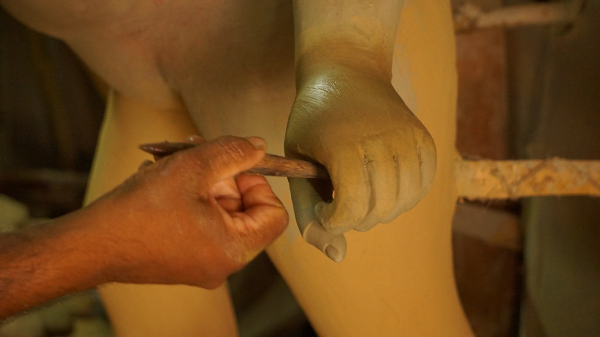 A hand is sculpting a statue.