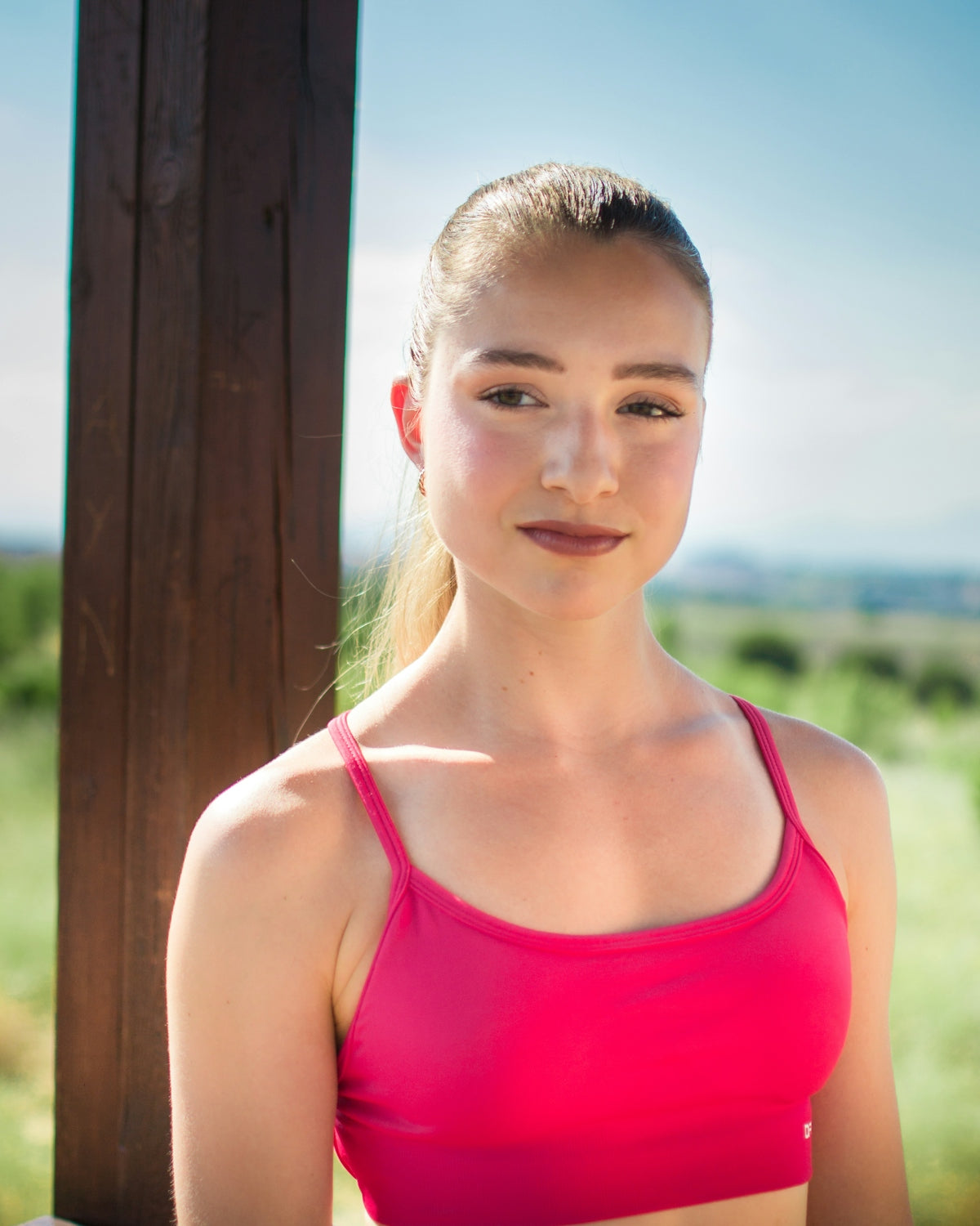 Young woman in pink sports bra outdoors
