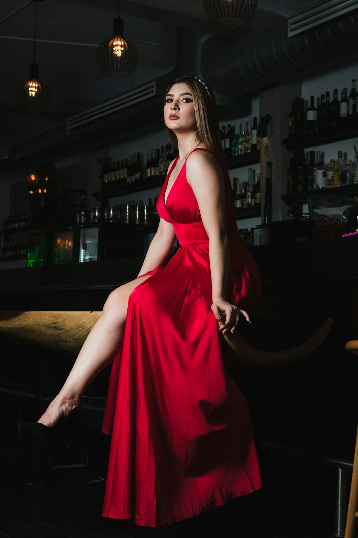 Woman in a red dress sitting at a bar