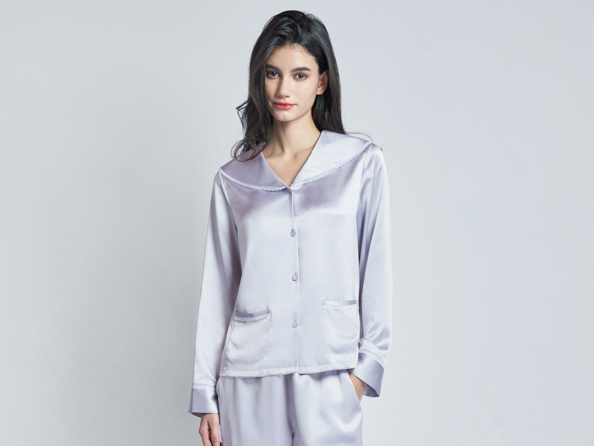 A woman wearing a light purple silk pajama set.