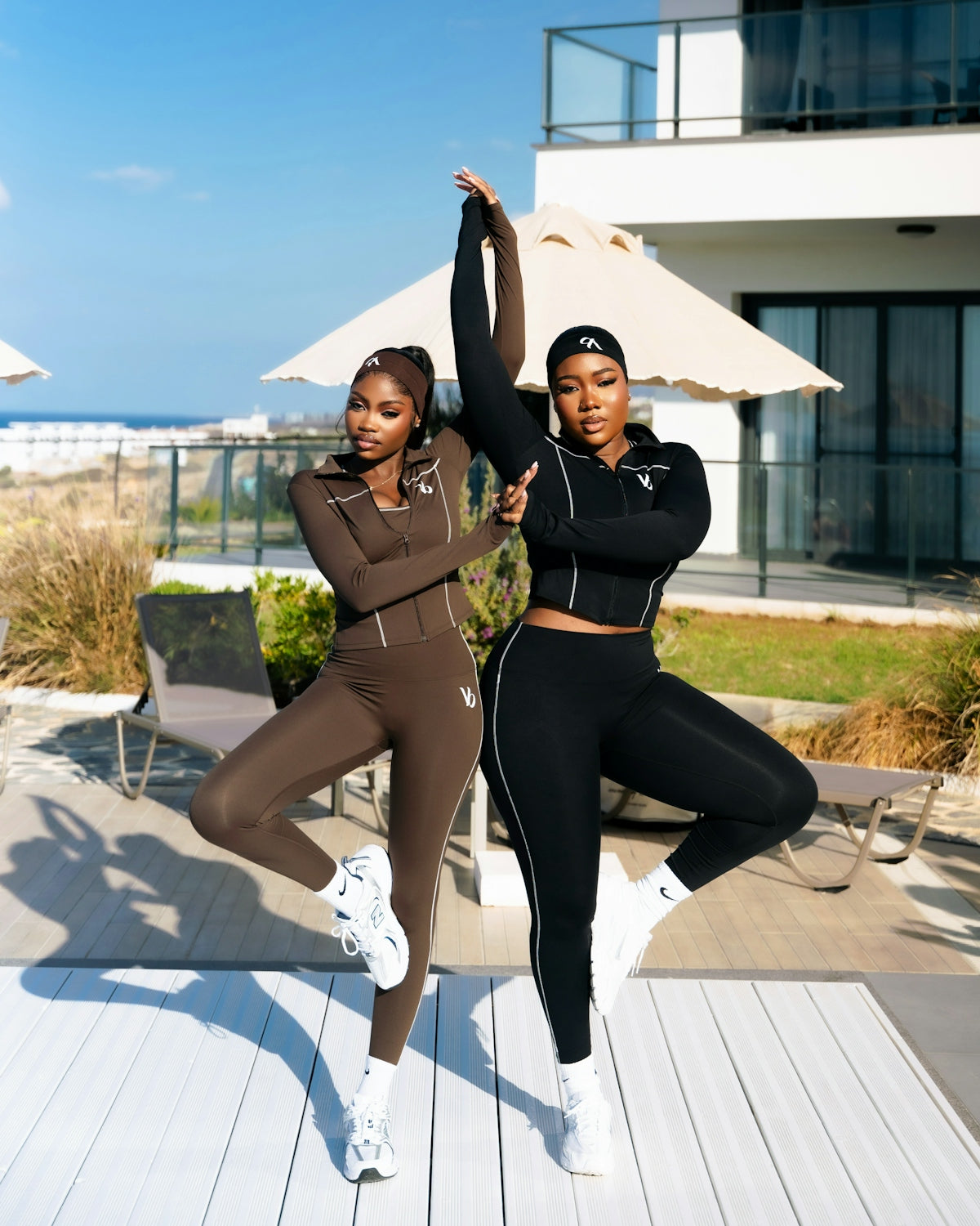 Two women in athletic wear striking a yoga pose