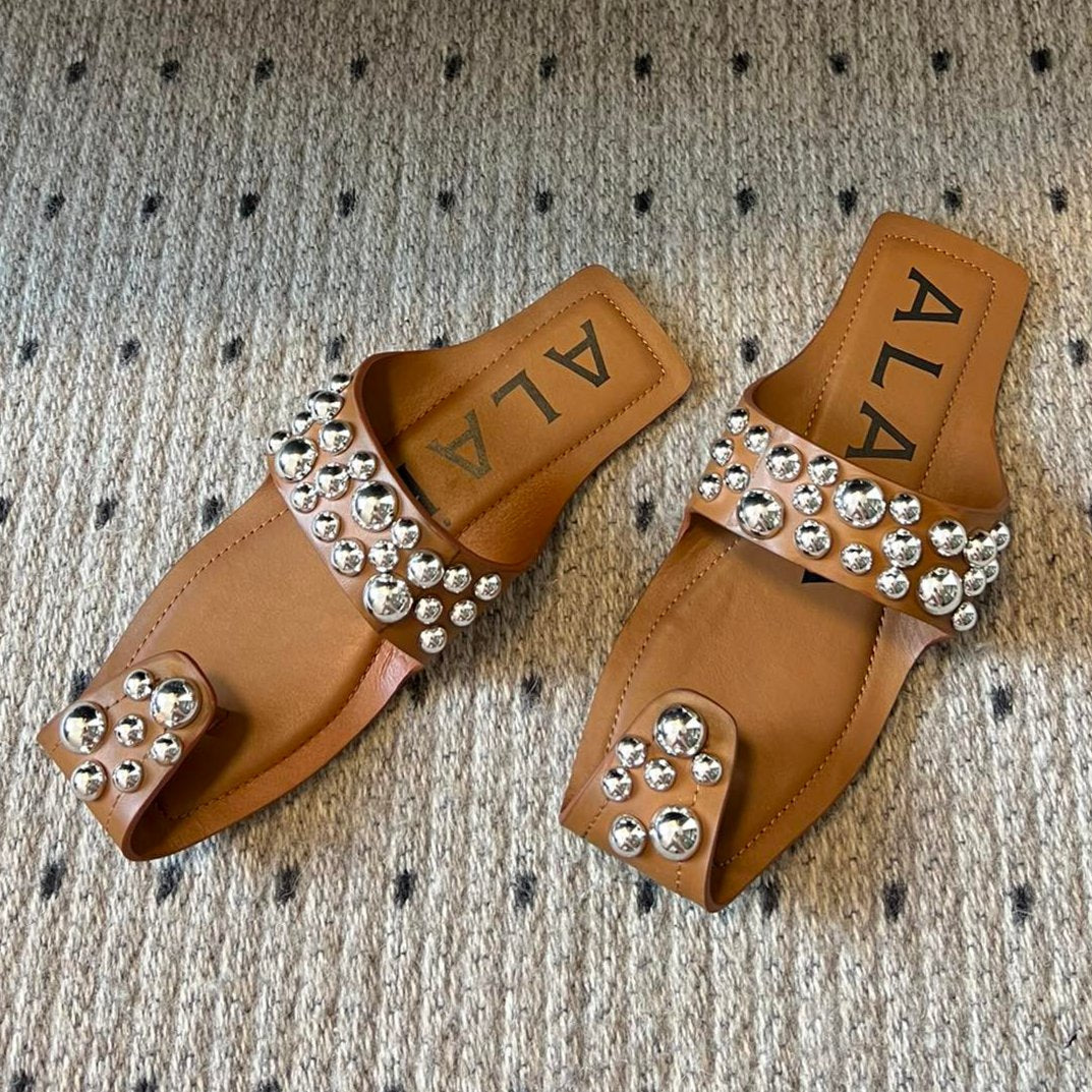 ALAIA FOLDED FLAT MULES WITH SPHERES ON COPPER BROWN CALFSKIN